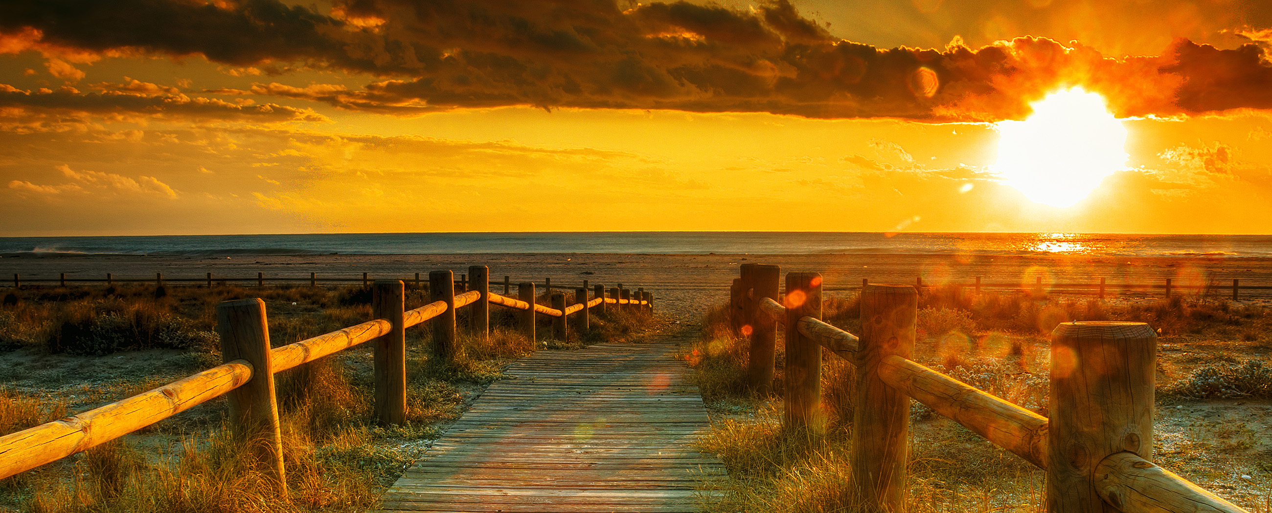 Boardwalk path leading into a warm sunset representing the therapeutic journey